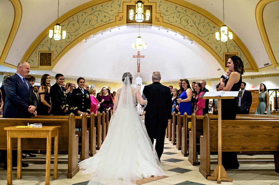 A bride and her dad walking into the church.